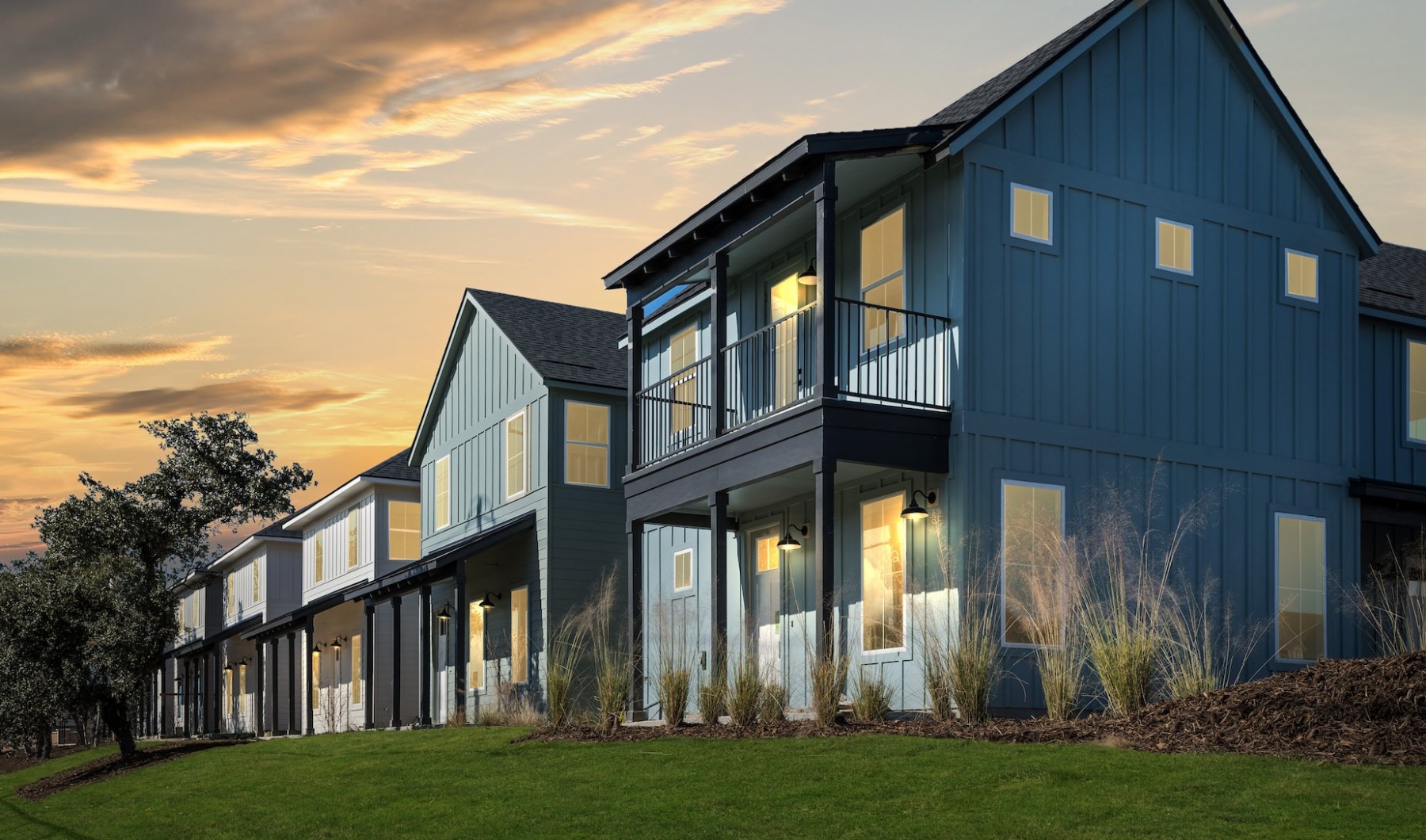 Blue apartment buildings under a vibrant orange sunset sky