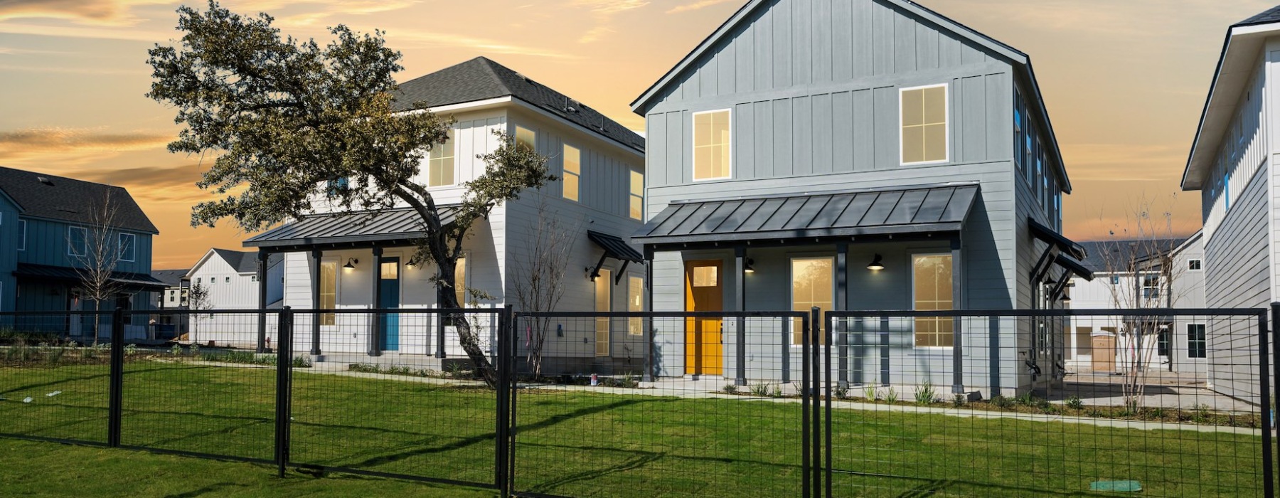 View of Birdsong Sonoma Ranch apartment buildings with a black gate in front