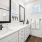  A pristine bathroom featuring sleek white cabinets complemented by elegant black fixtures 