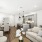 A contemporary kitchen and living room with crisp white walls and warm wood flooring