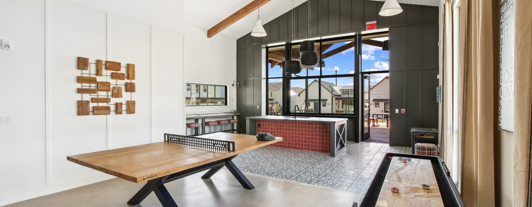 Recreational room with a ping pong table, shuffleboard, and a view of outdoor seating area